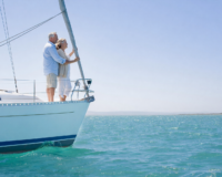 Senior adult couple on a sailboat looking on the horizon