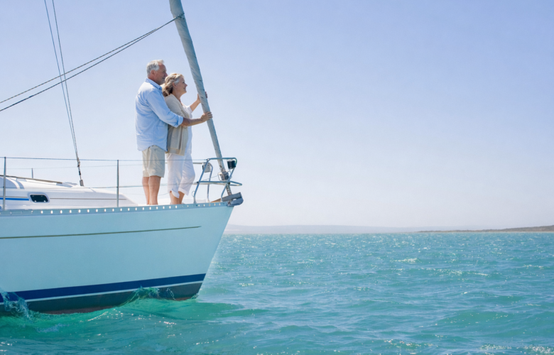 Senior adult couple on a sailboat looking on the horizon